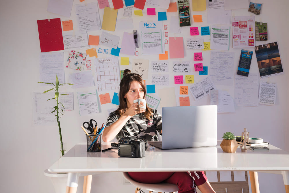 Imagem na Seção "Criação de Conteúdo" do Artigo "O que é Marketing Digital" - Mulher Sentada Criando Conteúdo com Lousa Toda Escrita