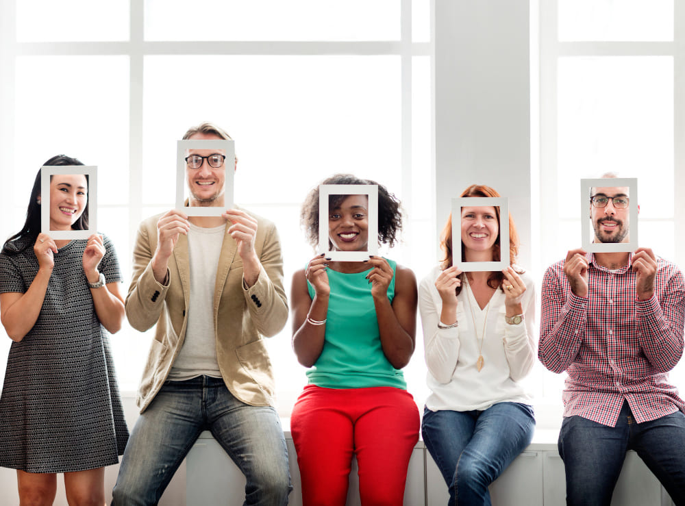 Imagem na Seção "Personas do Comprador" do Artigo "O que é Marketing Digital" - Grupo de Amigos com Molduras de Quadro Vazias para Representar Personas